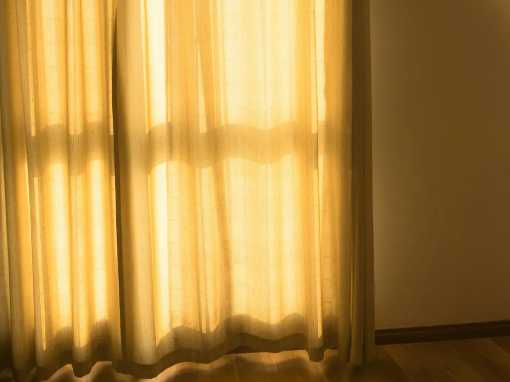 Low golden sun through sheer linen curtains